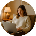 Mujer sentada cómodamente en un sofá usando una laptop, simbolizando la facilidad de la compra online en Fajas Salome.